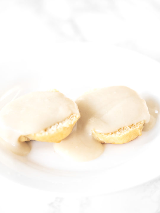 Biscuits and gravy without meat on a white plate on a white marble counter