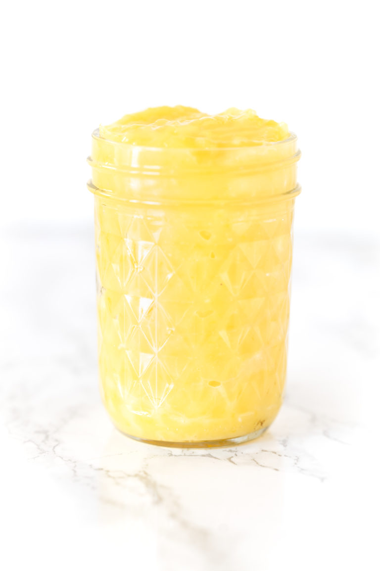 lemon curd in a jar on a white marble counter