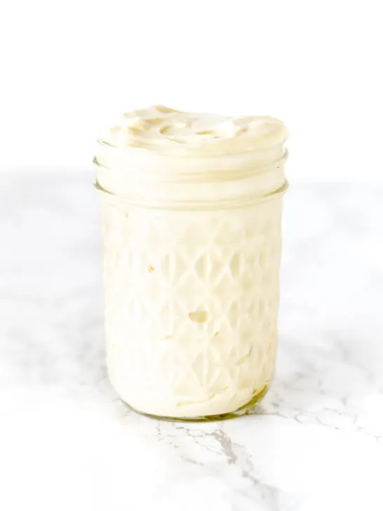 mayonnaise in a glass jar on a white marble counter