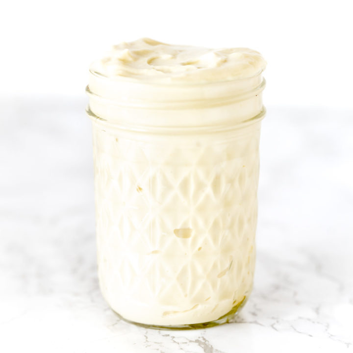 mayonnaise in a glass jar on a white marble counter