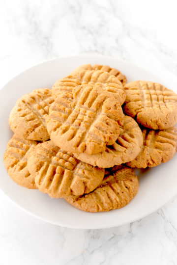 peanut butter cookies on a white plate on a white marble counter