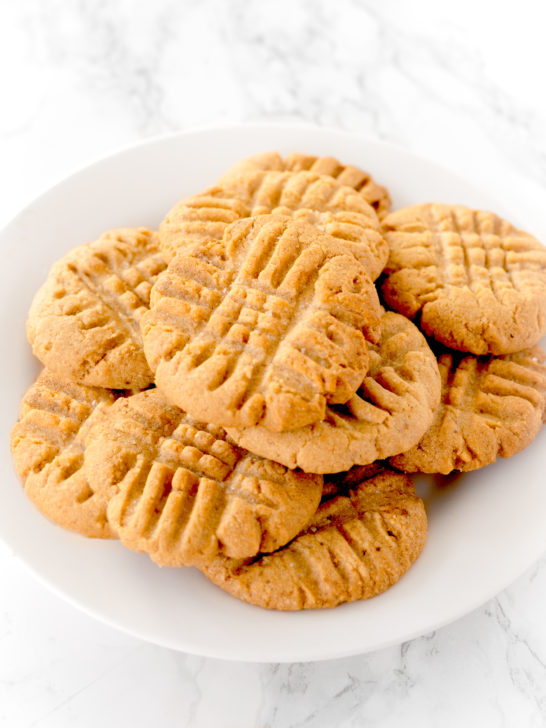 peanut butter cookies on a white plate on a white marble counter