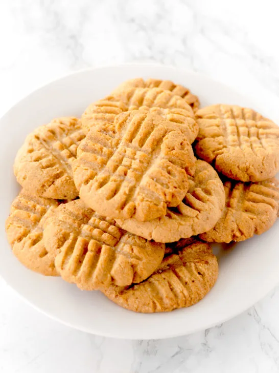 peanut butter cookies on a white plate on a white marble counter