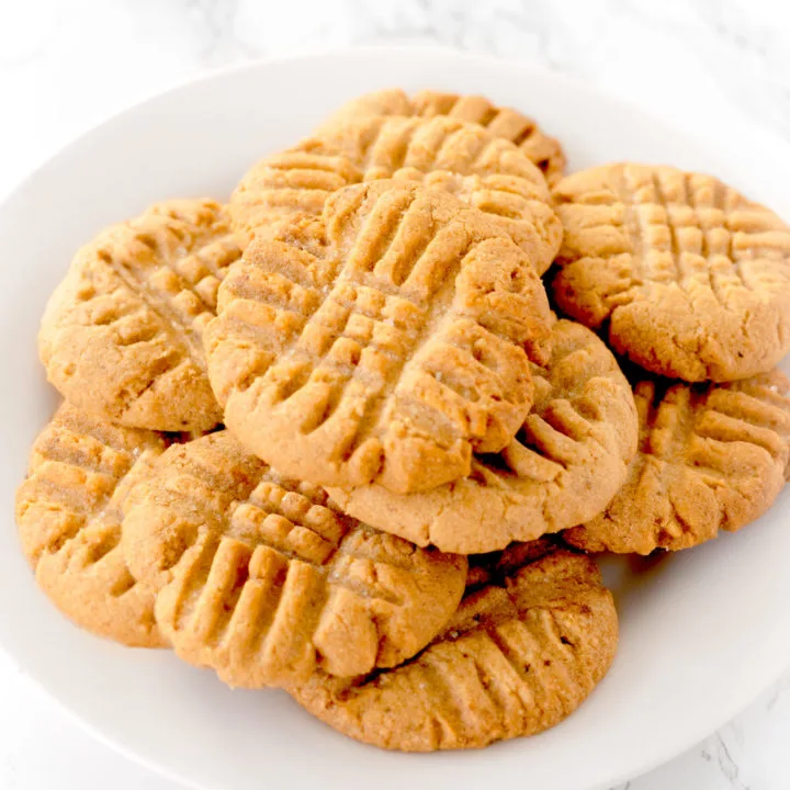 peanut butter cookies on a white plate on a white marble counter