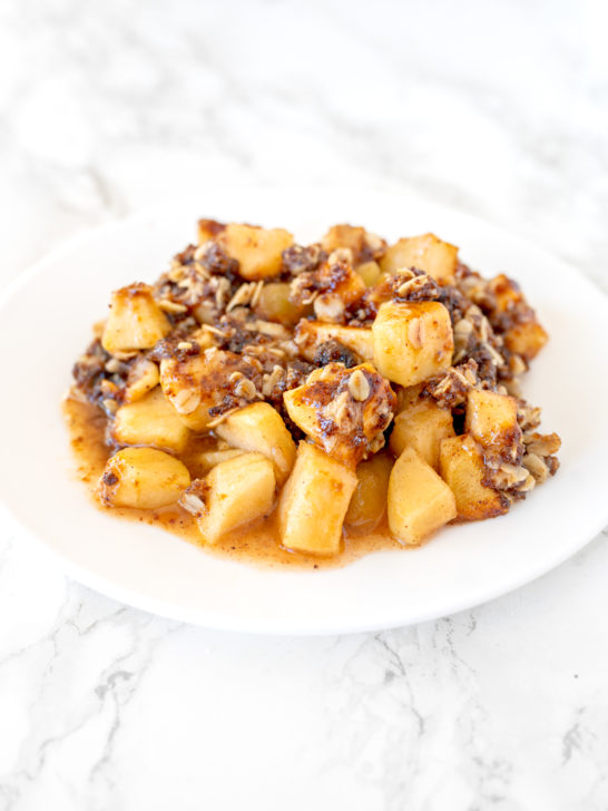 apple crisp on a white plate on a white marble counter