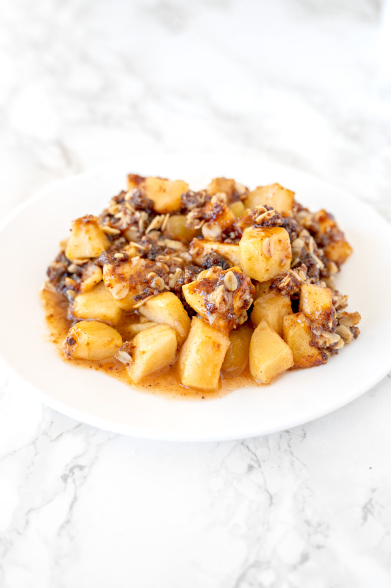 apple crisp on a white plate on a white marble counter