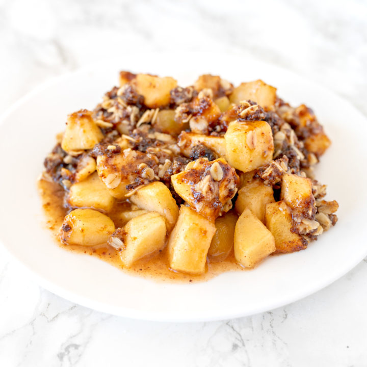 apple crisp on a white plate on a white marble counter
