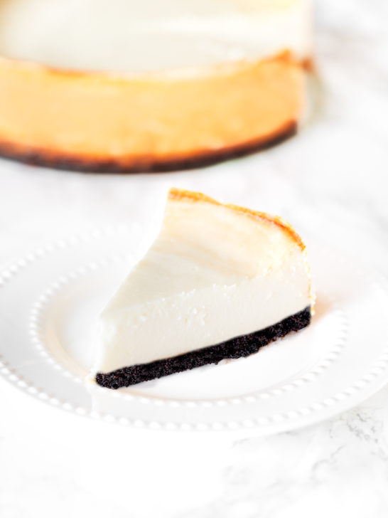 brownie bottom cheese cake on a plate on a white marble counter