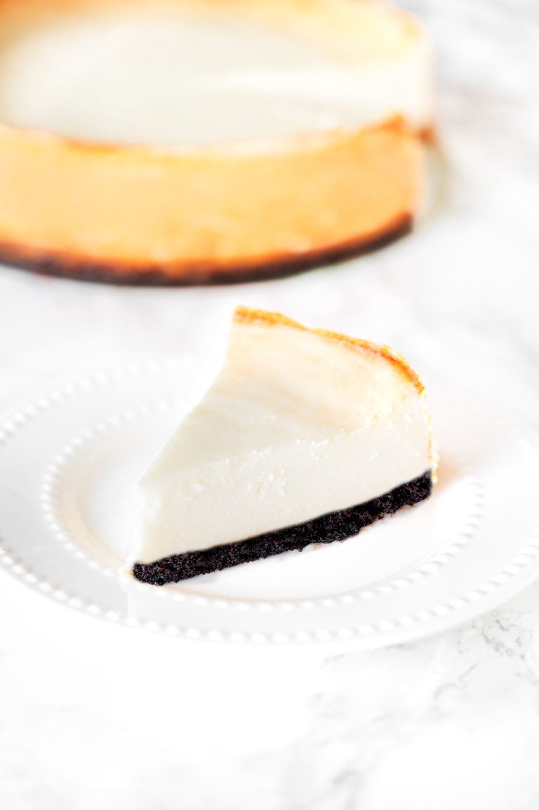 brownie bottom cheese cake on a plate on a white marble counter