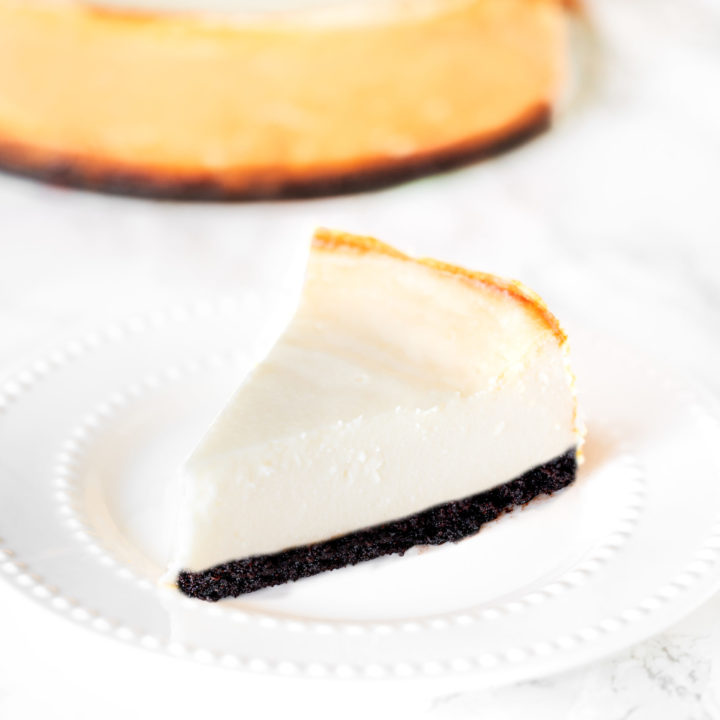 brownie bottom cheese cake on a plate on a white marble counter