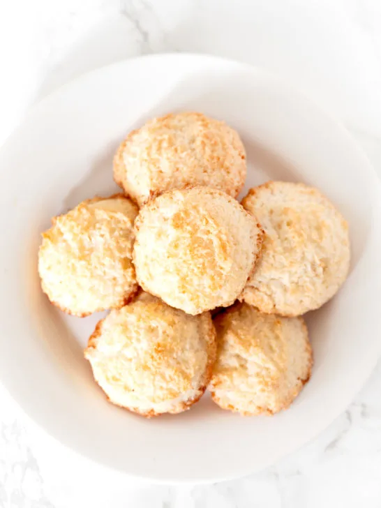 coconut macaroons on a white plate on a white marble counter