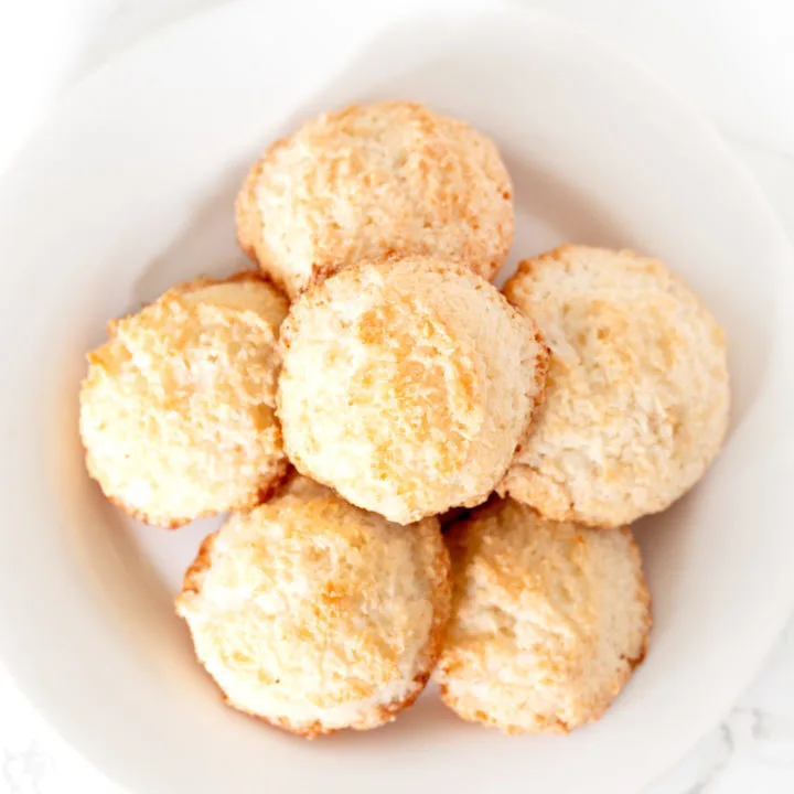 coconut macaroons on a white plate on a white marble counter
