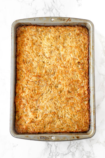 potato kugel in a baking pan on a white marble counter