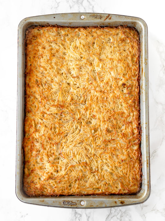 potato kugel in a baking pan on a white marble counter
