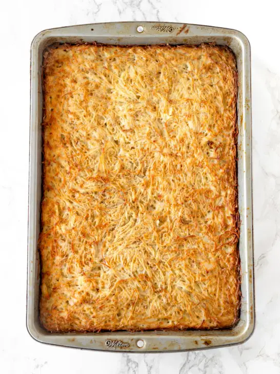 potato kugel in a baking pan on a white marble counter