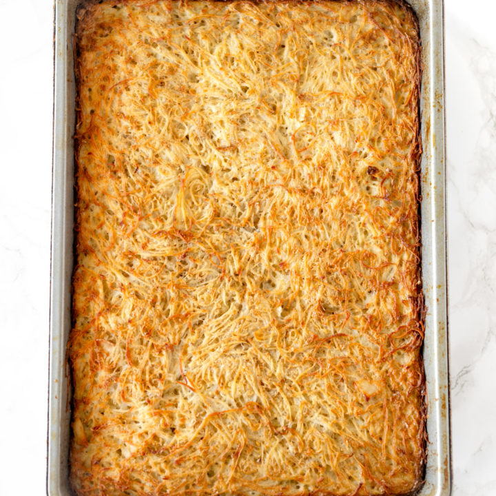 potato kugel in a baking pan on a white marble counter