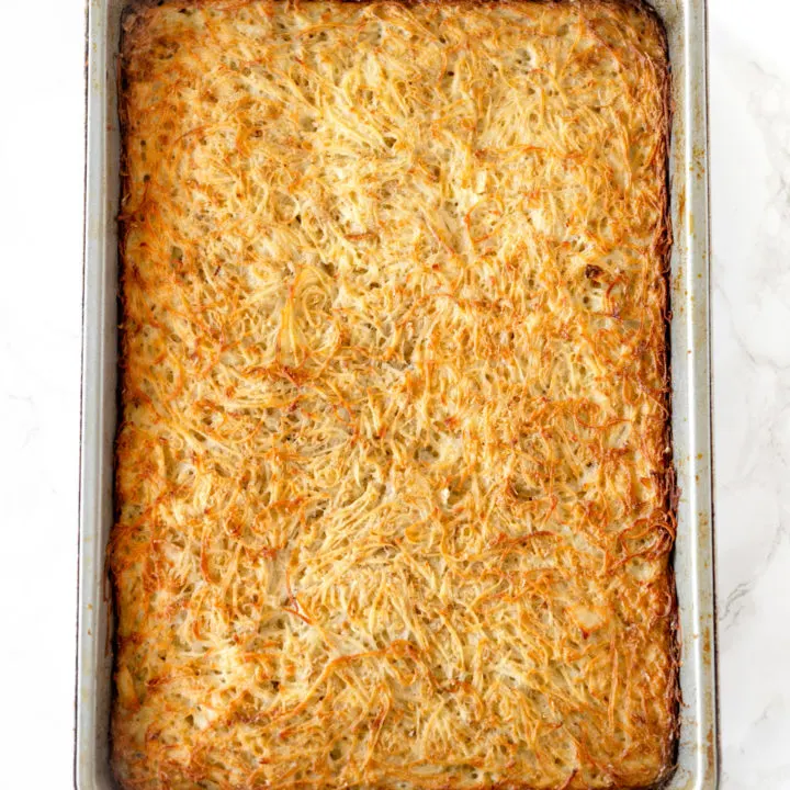potato kugel in a baking pan on a white marble counter